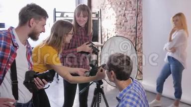 摄影学校，数码单反相机的年轻创意摄影公司正在专业摄影工作室培训摄影